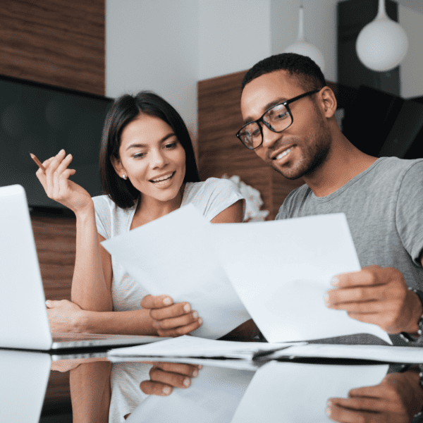 Cheerful couple analyzing their finances with documents.