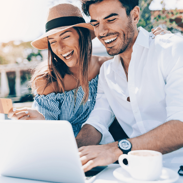 Wealthy young couple with credit card and laptop.