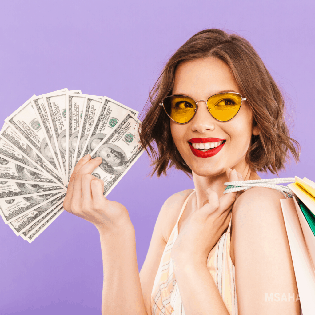 Woman holding shopping bags over her shoulder and cash on the other hand and smiling.