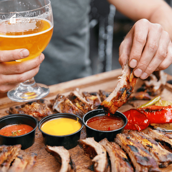 a woman eating variety of grilled meat on a table