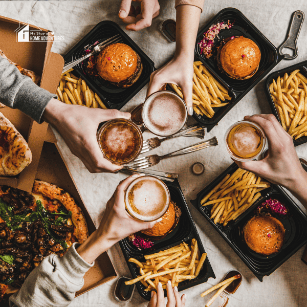 group of friends eating burger, fries and beer