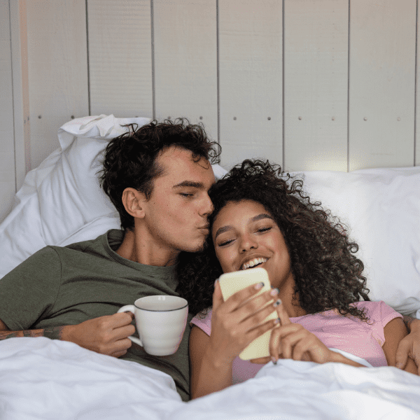 couple waking up in bed while on a staycation.