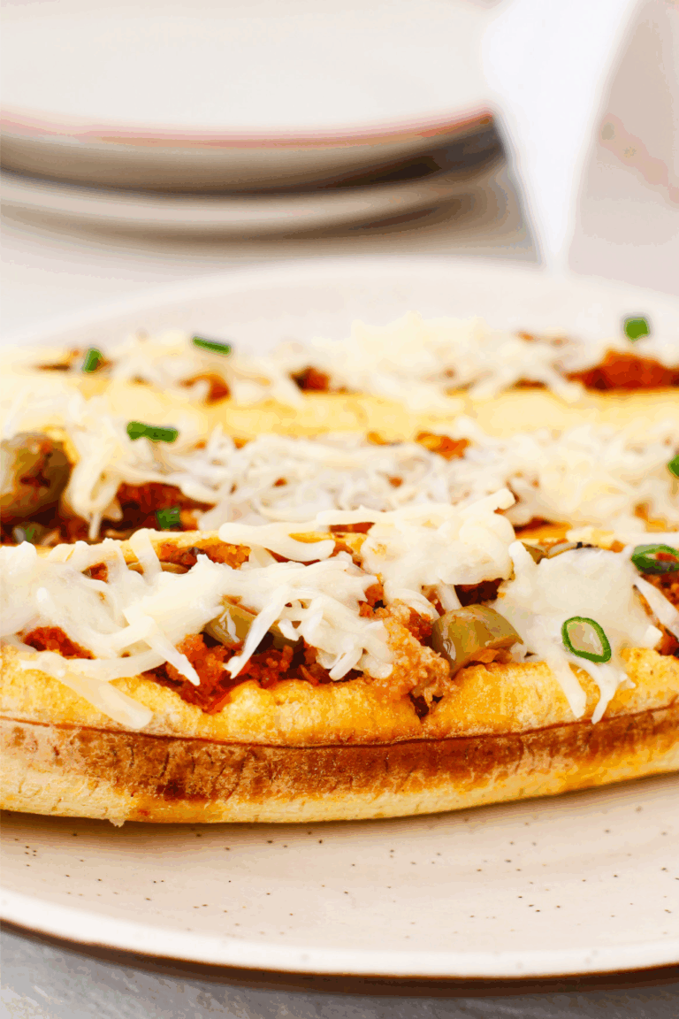 Stuffed baked plantains (canoas de plátanos maduros) filled with seasoned ground beef, olives, and melted cheese, served on a white plate