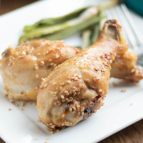 2 Low Carb Air Fryer Sesame Chicken Legs served on a white plate.