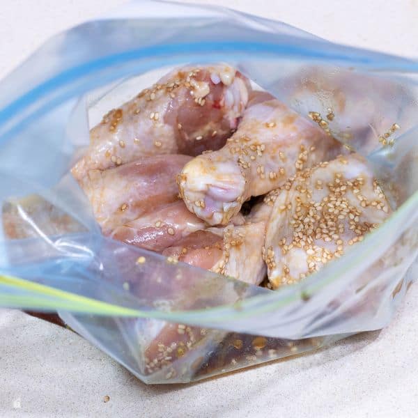 raw chicken leg marinated inside a bag.