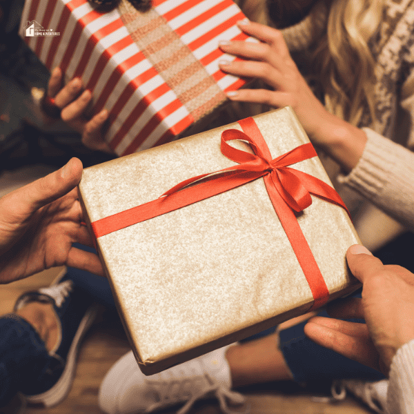 Partial view of couple giving gifts while celebrating Christmas