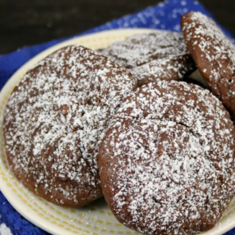 Sea Salt & Caramel Nutella Cookies arranged on a white plate with a sprinkle of powdered sugar.