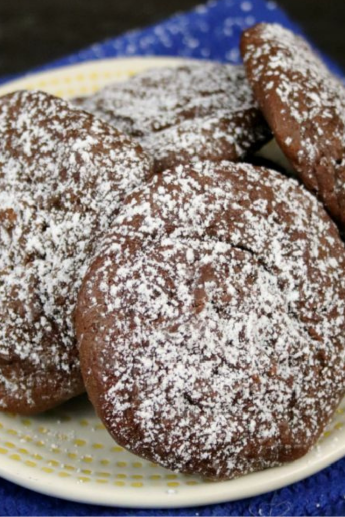 Sea Salt & Caramel Nutella Cookies arranged on a white plate with a sprinkle of powdered sugar.