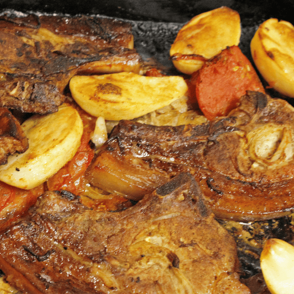 Oven baked pork chops with potatoes and tomatoes.
