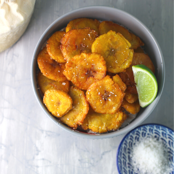 Tostones in a blow with a lime on top.