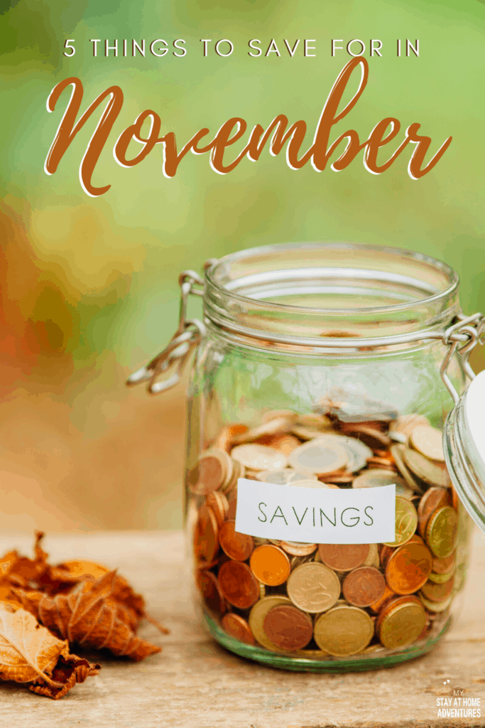 Glass mason jar full of coins with fall leafs next to it.