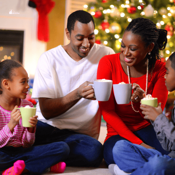 Family of four sharing hot cocoa on Christmas Morning