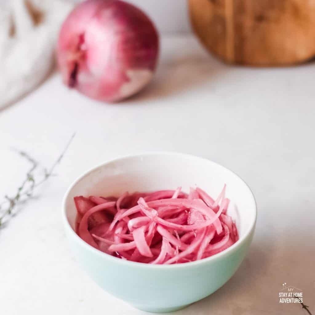 Photo of pickled red onions served in a small bowl.