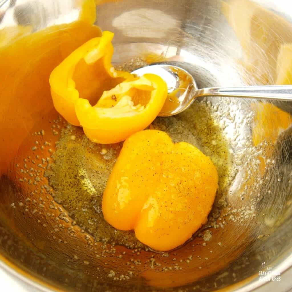 peppers in a bowl coated with olive oil and other seasonings.