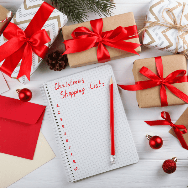 A festive Christmas shopping scene with wrapped gifts, a shopping list, and a pencil, symbolizing holiday planning, budgeting, and managing Christmas gift expenses.