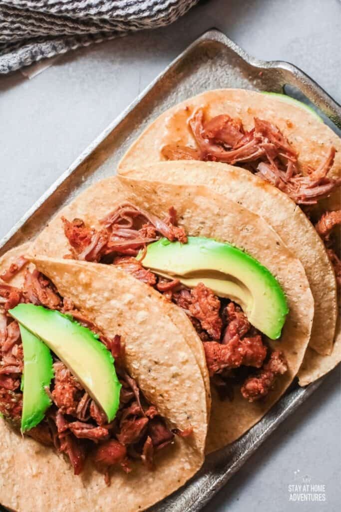 Top view of three pork tacos served
