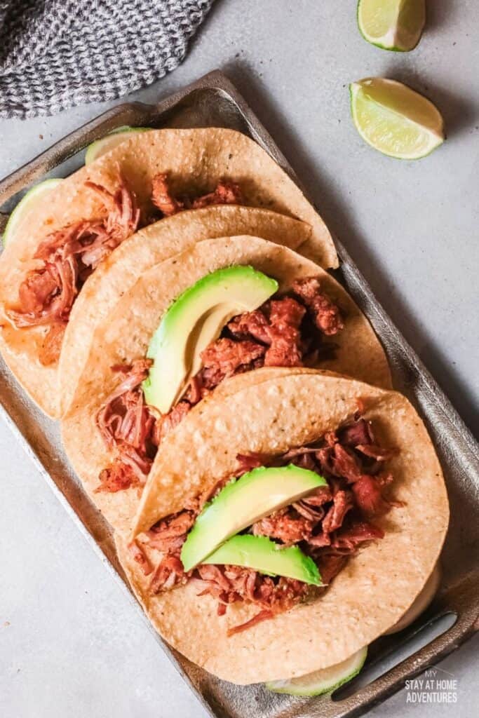 top view of three pork tacos served 