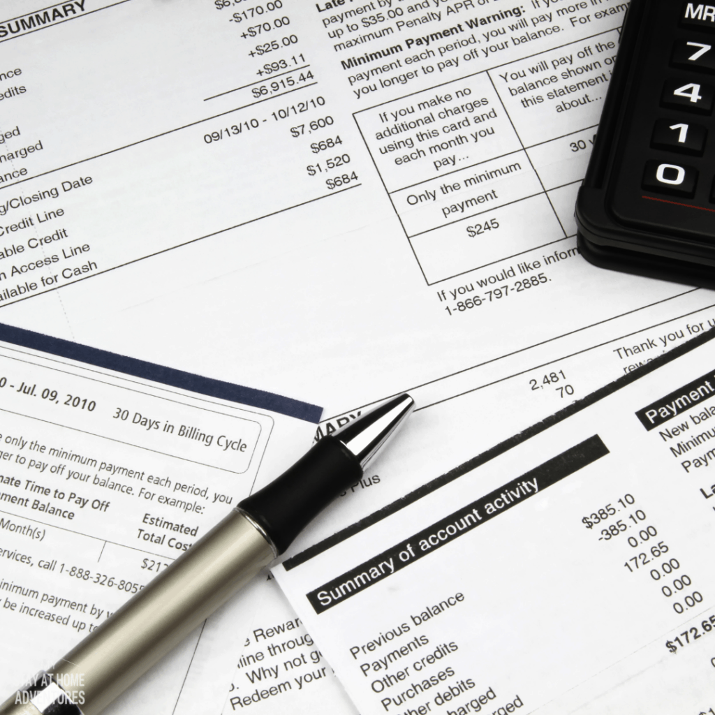 Stacks of bill and above a silver and black pen and black calculator