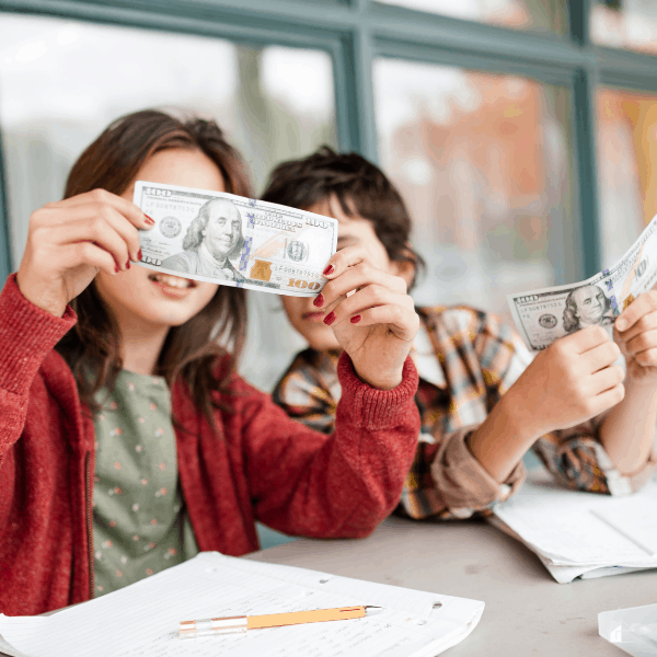 Children studying $100 bills closely
