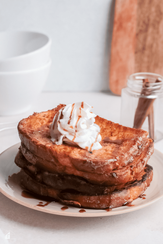 Close up of eggnog french toasts topped with whip cream