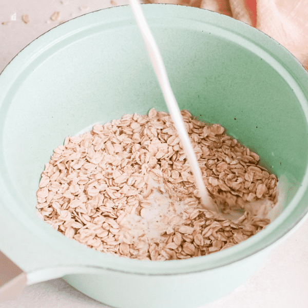 milk pouring over oats that are inside a pot