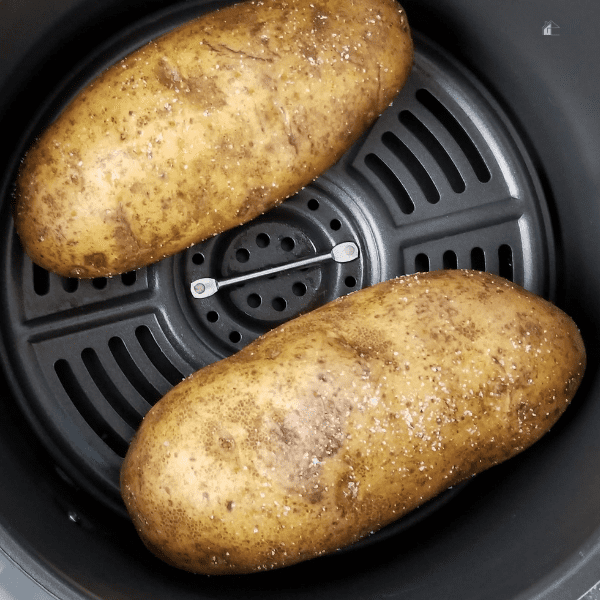 two potatoes inside an air fryer