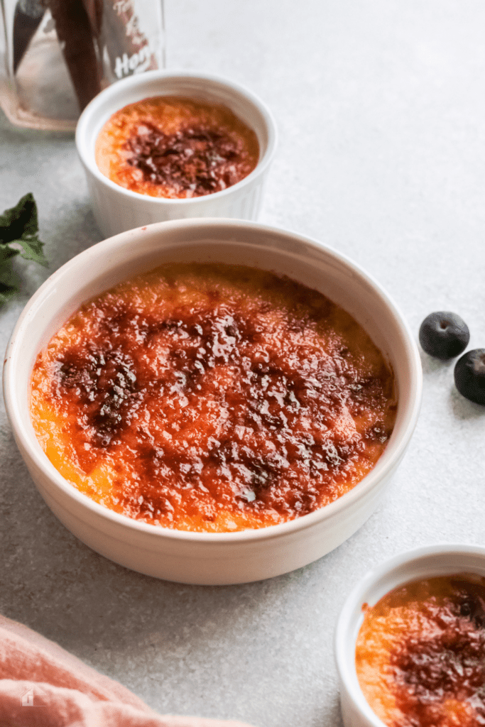 Crema Catalana served. Gray countertop with blueverrys and as decor.