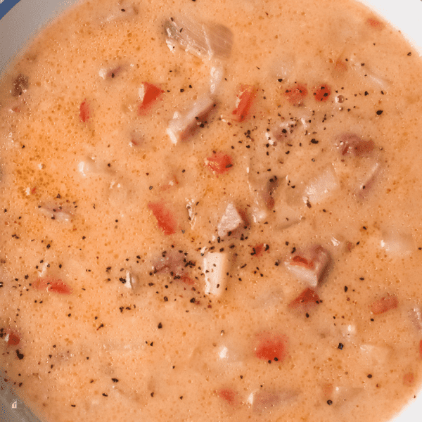 Close up of ham potato soup topped with salt and pepper.