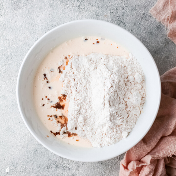 Gordita de Nata batter with flour on top in a large white bowl.