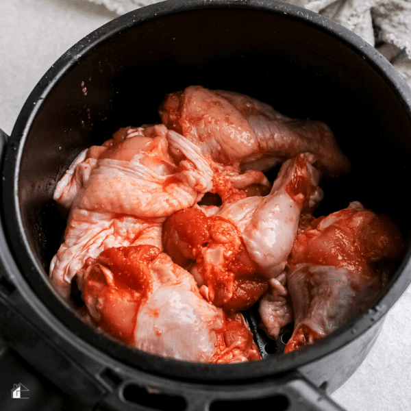 raw wings inside an air fryer basket