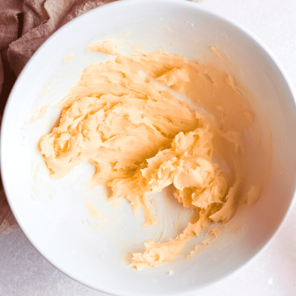 Creamed butter with sugar in a white mixing bowl.