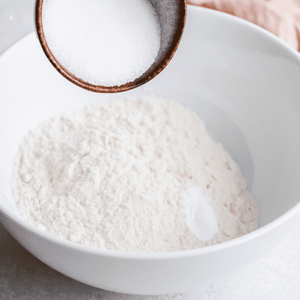 adding baking powder to flour, sugar and salt mix.