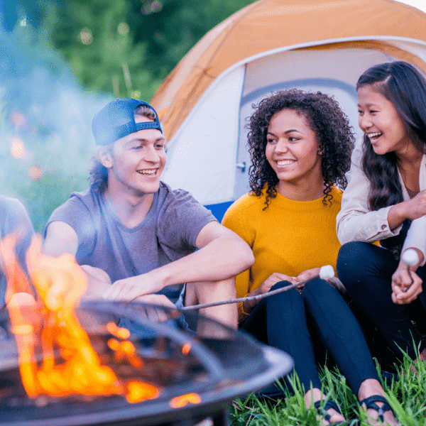 Young adults enjoying a camp fire.