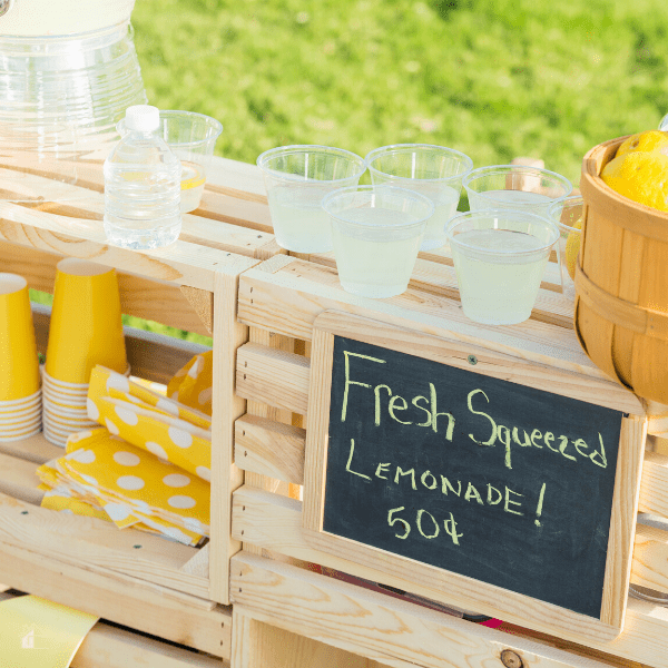 Neighborhood lemonade stand -lemonade stand set up in front of a house.