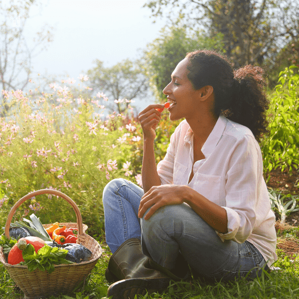 Woman eating vegetables in permaculture garden