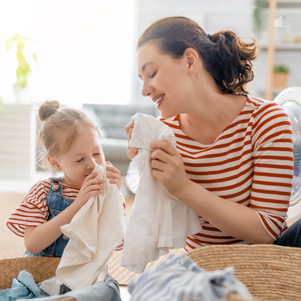 Are Laundry Sheets Worth Buying? - mom and daughter smiling and having fun while doing laundry.