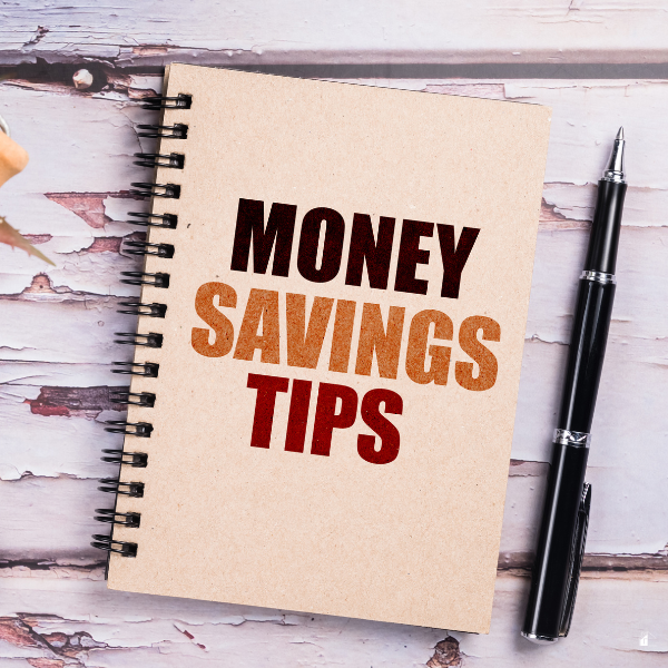 Money Savings Tips text on a small notepad with a pen.