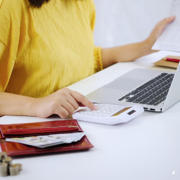 Woman Calculating budgeting using calculator and laptop