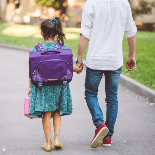 Girl with her father on her way to school.