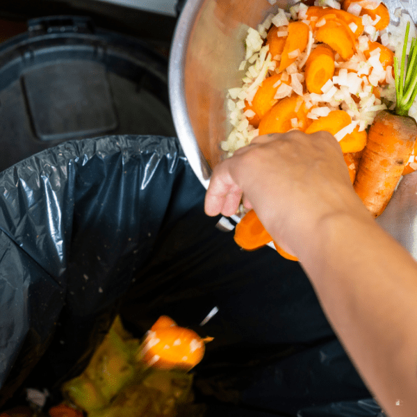 Someone throwing food in the trash.