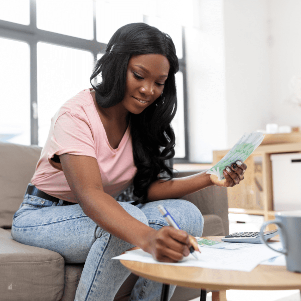 African American Woman Counting Money at Home