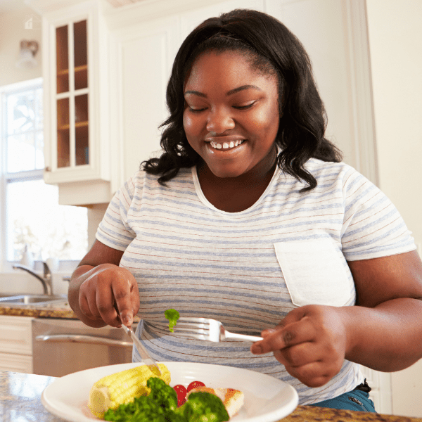 Woman eating a healthy simple meal in her kitchen.