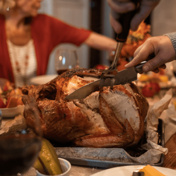 Thanksgiving Day family carving a turkey.