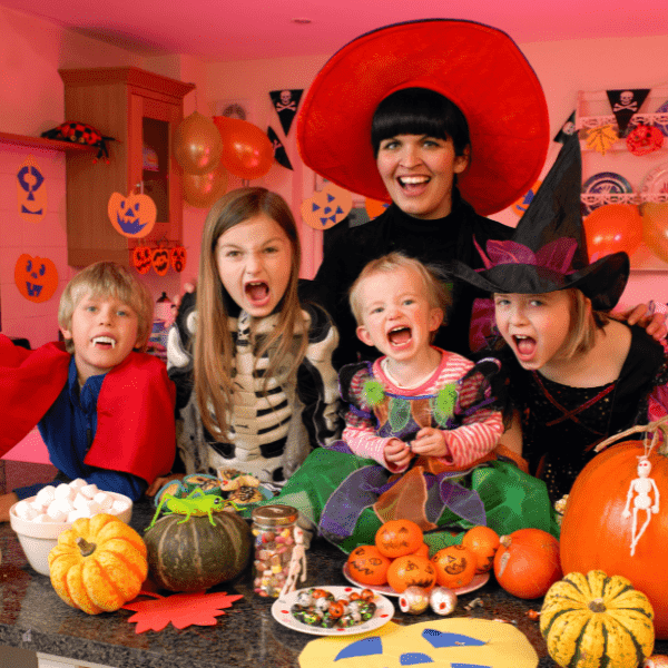 Family posing for the camera in their Halloween costume in a party.