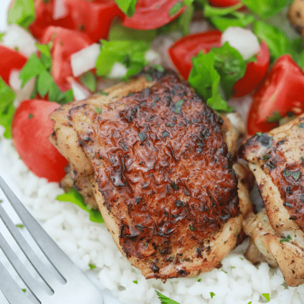 Chicken thighs severed over white rice.
