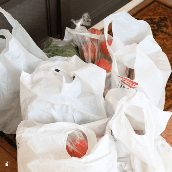 White plastic bags full of grocery delivered to door steps.