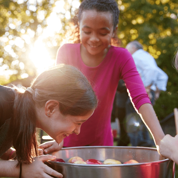 Young Girls Laugh While Apple Bobbing