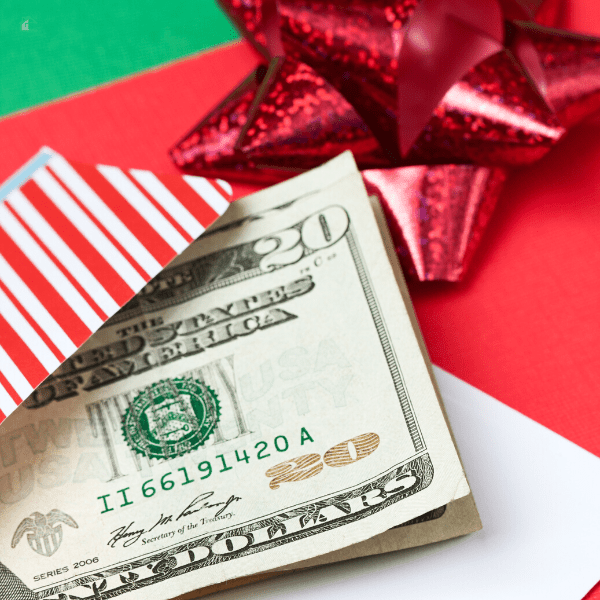 $20 bills ontop of Christmas wrapping and red ribon.
