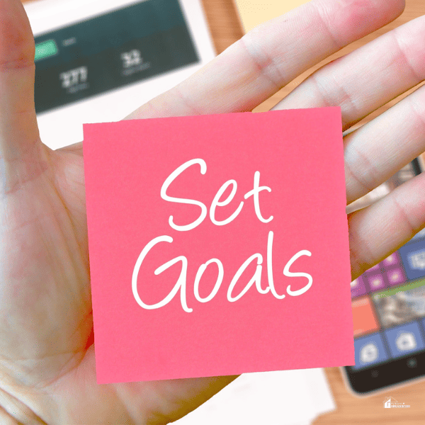 Set goals in a pink sticky note