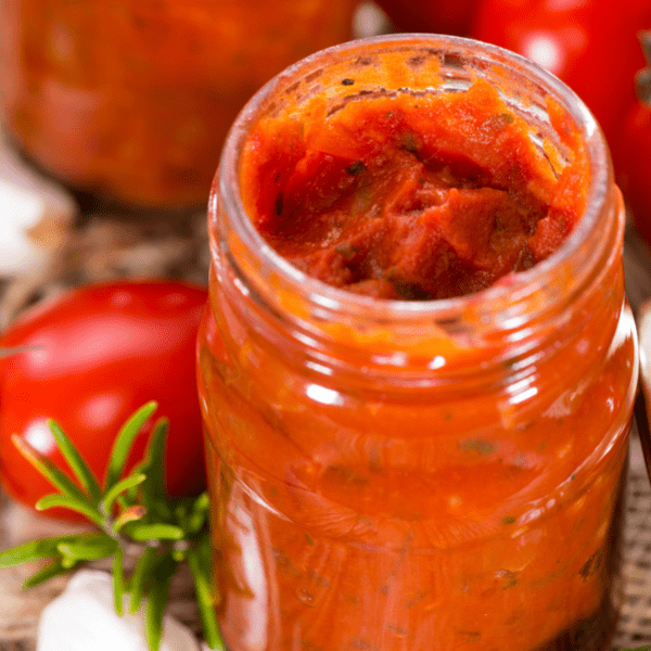 Homemade tomato sauce with basil and garlic on an old vintage table.